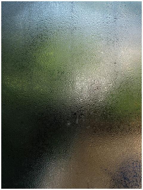 Close-up view of a wet glass pane with water dropl