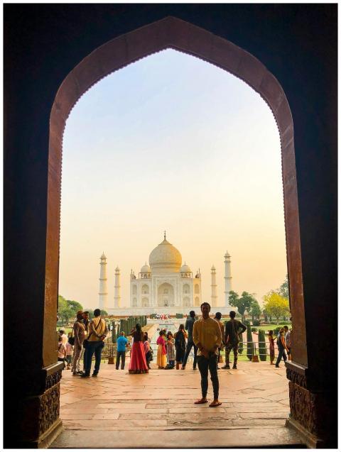Tourists admire the majestic Taj Mahal framed by a