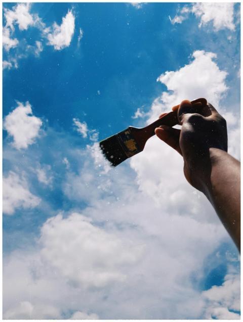 Artistic view of a hand holding a paintbrush in a