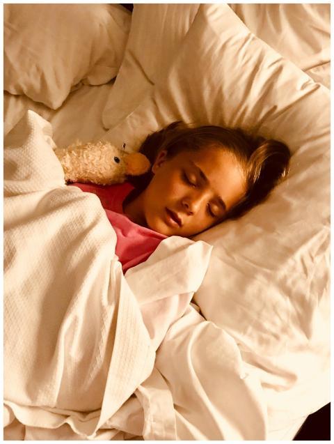 Young girl sleeping peacefully with stuffed animal