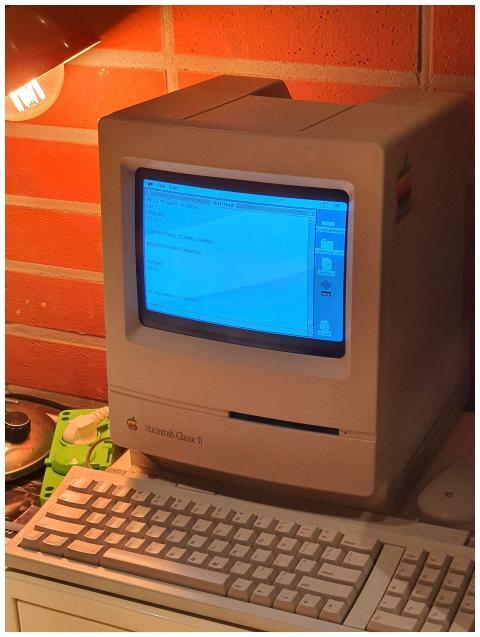 A vintage Macintosh computer with a keyboard under