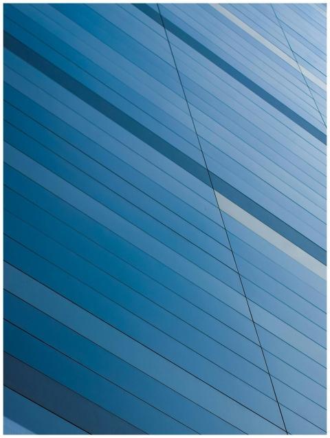 Abstract view of a modern blue glass building faca