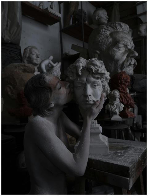 Creative sculptor in a cluttered studio with vario