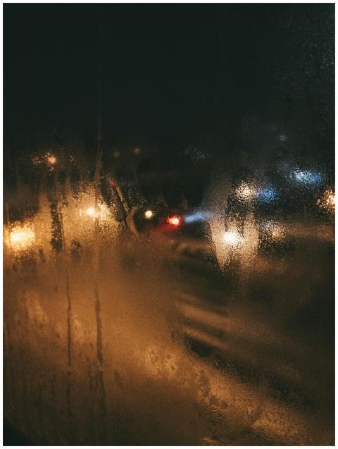 Blurry city lights seen through a wet glass window