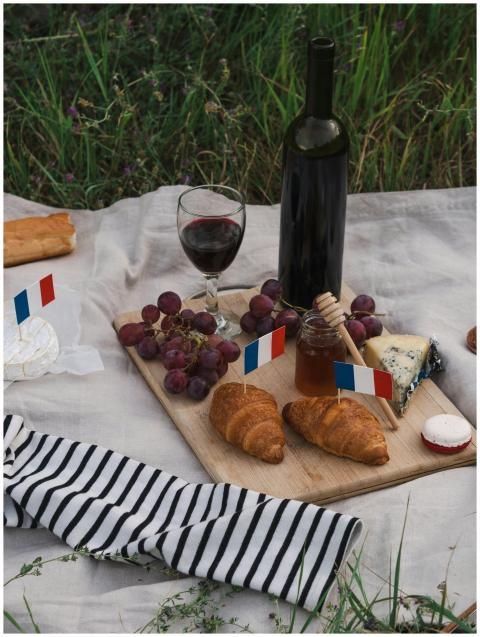 A delicious French picnic setup with wine, cheese,