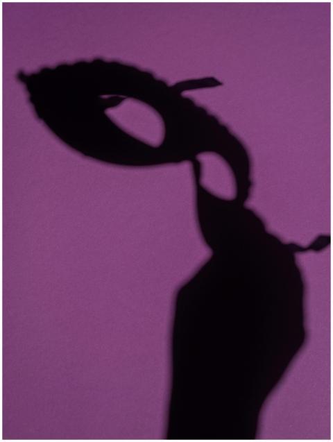 Silhouette of a masquerade mask casting a shadow o