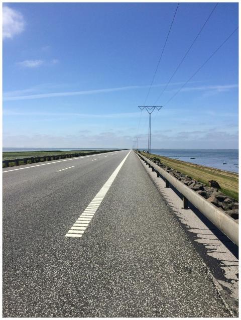 Empty asphalt road on Rømø Island, Denmark, with s