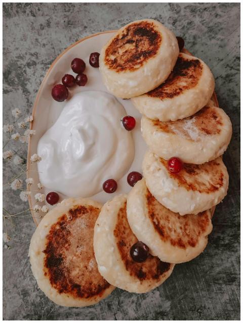 Close-up of scrumptious syrniki topped with cream