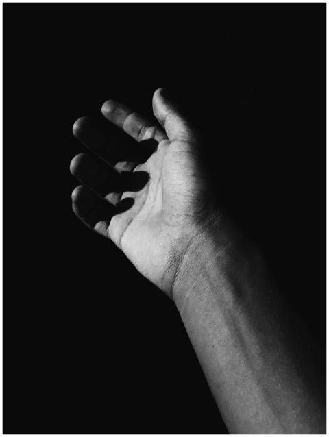 High-contrast monochrome photo of an open hand aga