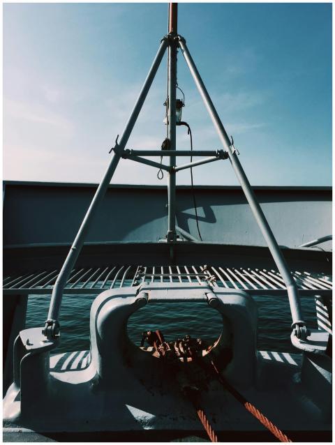 Close-up of a ship's metal structure and ropes ove