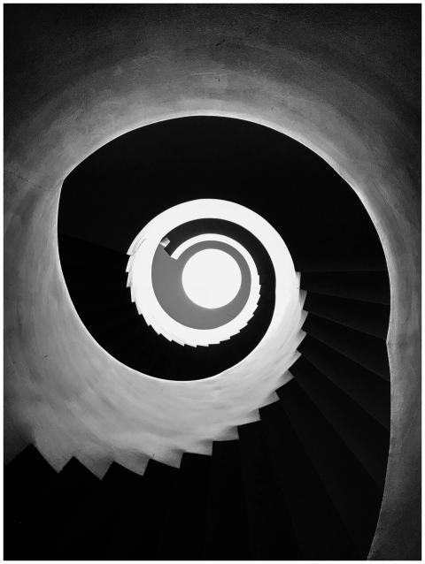 A black and white spiral staircase viewed from bel