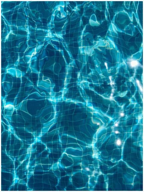 Abstract view of sunlit ripples in a clear blue sw