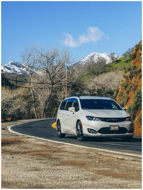 Minivan driving along a winding mountain road with