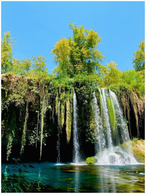 A serene waterfall cascading down rocks surrounded