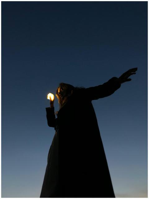 Artistic silhouette of a woman holding a light dur