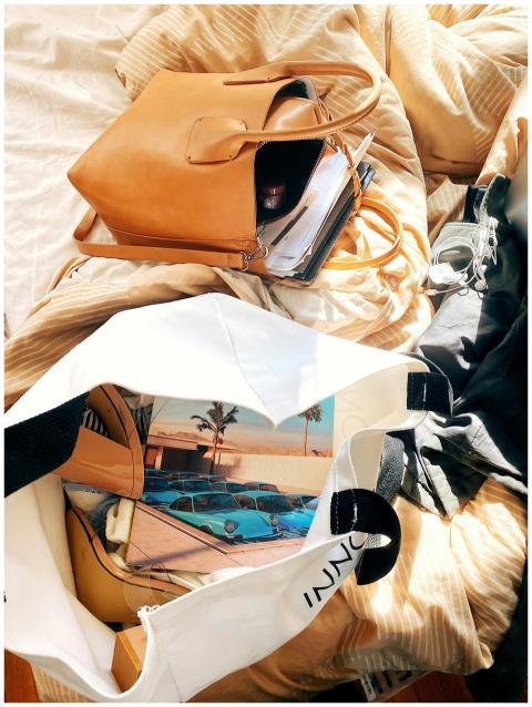 A stylish leather bag and open tote with travel it