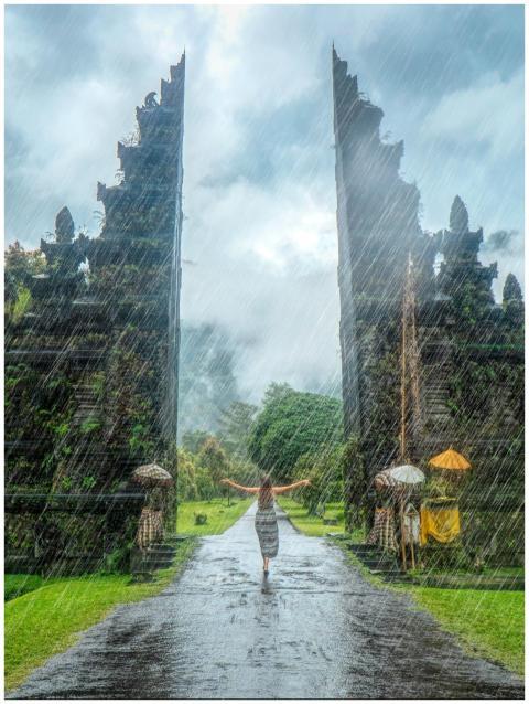 Woman in vibrant rain at iconic Handara Gate, Bali