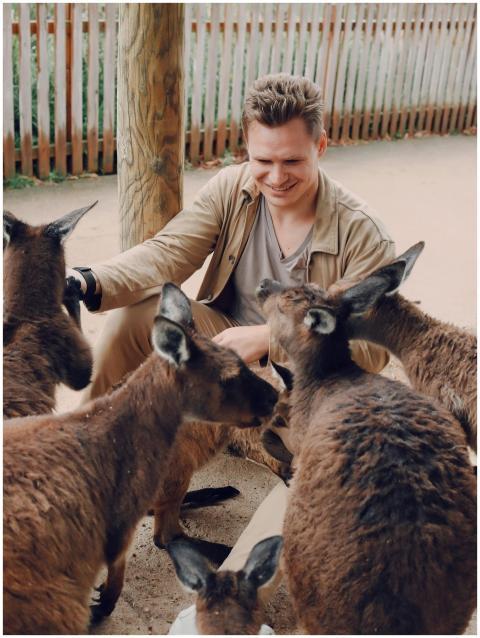 Full body of smiling content blond male in casual