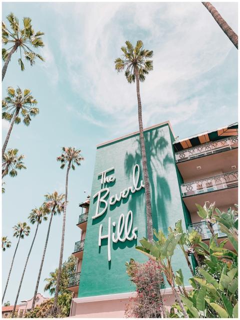 The Beverly Hills Hotel with palm trees under a cl