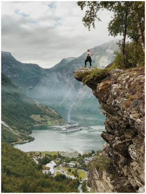 Person enjoys breathtaking view from a cliff above