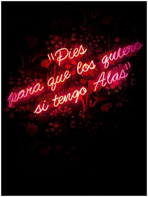 Neon text art with Spanish quote on black floral b