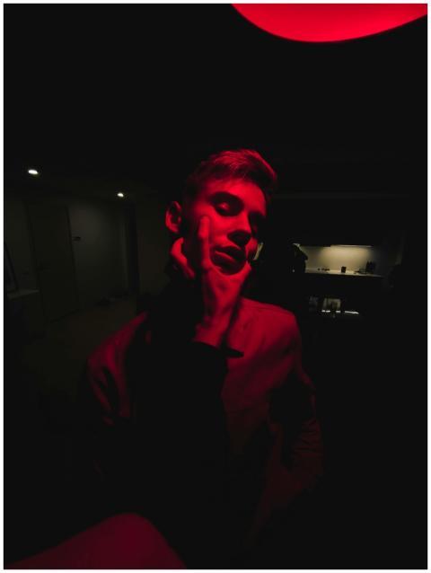 A dramatic portrait in red lighting capturing an e