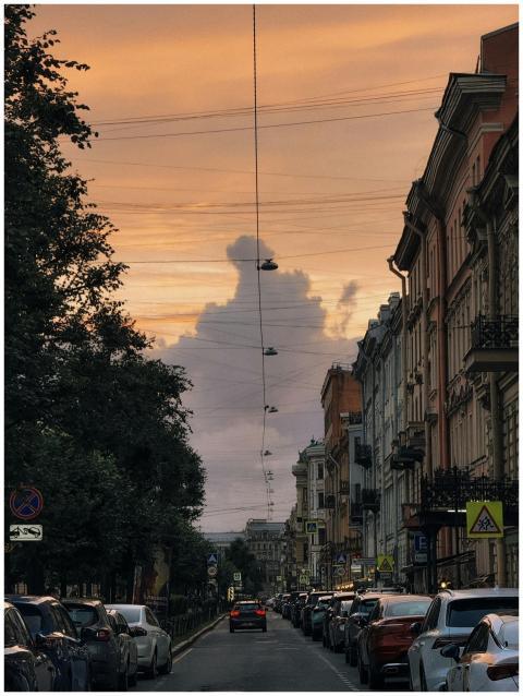 A bustling city street under a picturesque sunset
