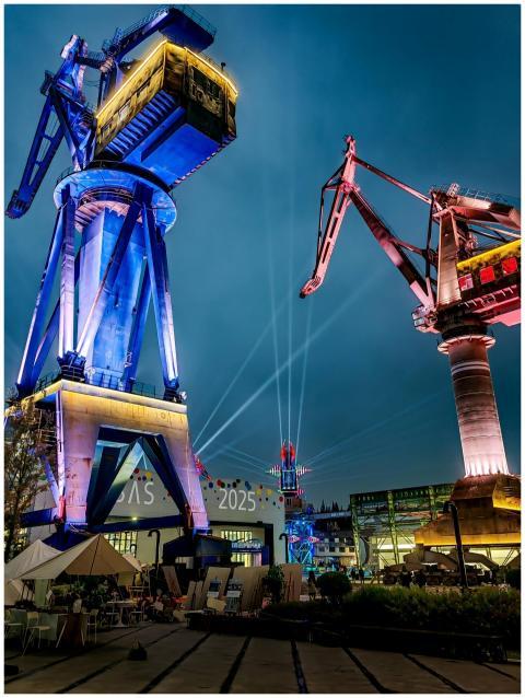 Colorful night view of towering illuminated cranes