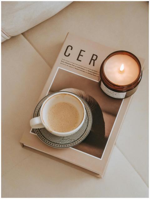 Warm and inviting flat lay with coffee, candle, an