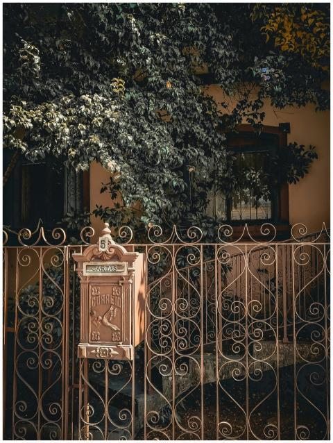 Ornate iron gate with mailbox, vintage design surr