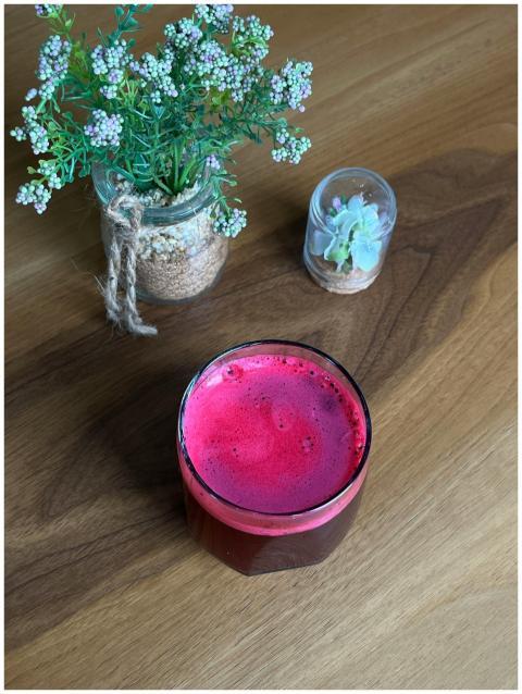 Bright beetroot juice beside small decorative plan