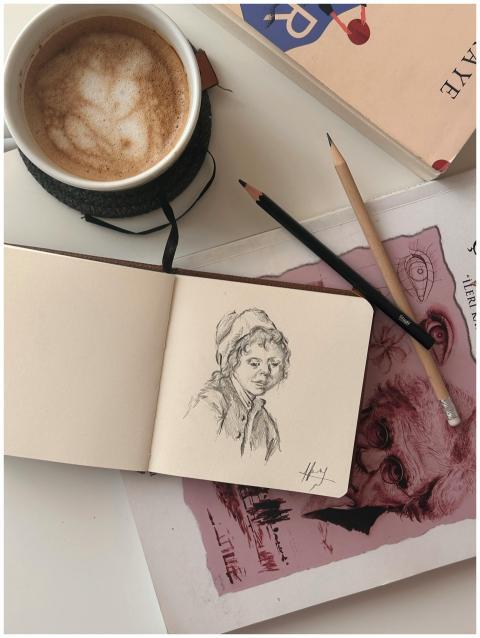 Cozy artist's workspace featuring a sketchbook, co