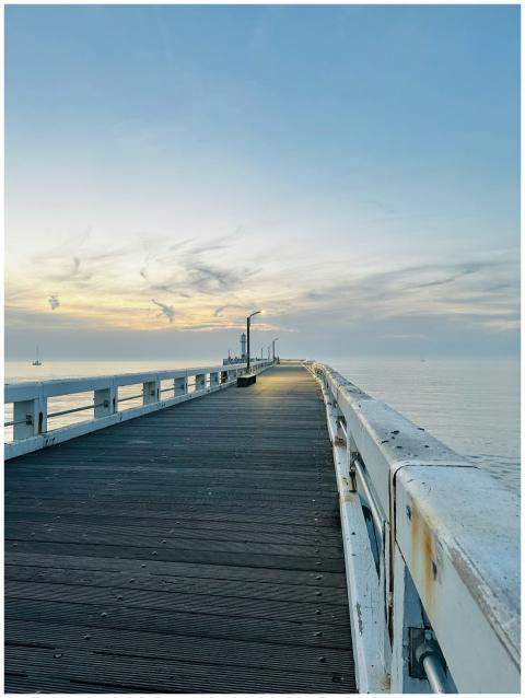Tranquil pier with sunrise over calm ocean, perfec