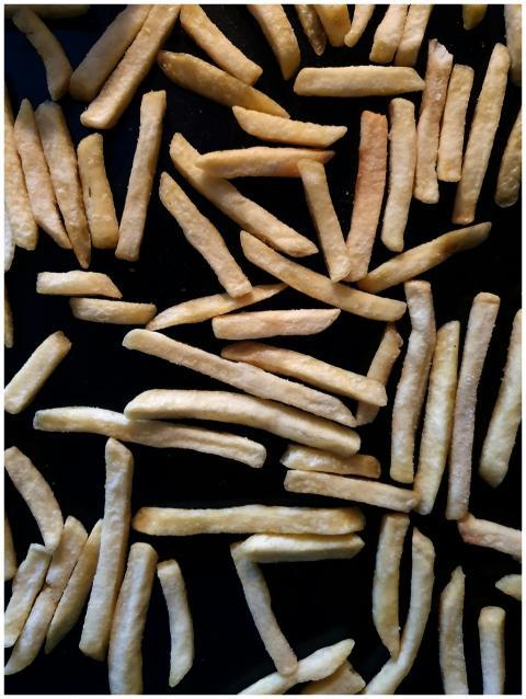 A high-angle shot of golden French fries scattered