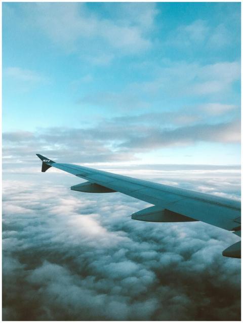 Aerial view of an airplane wing flying over fluffy