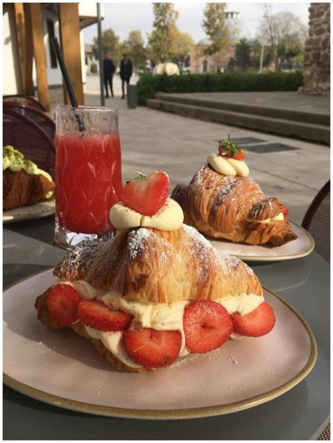 Tasty strawberry croissant with cream and fresh ju