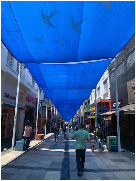 A bustling city street with people walking beneath