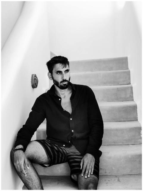 Black-and-white portrait of a fashionable man sitt