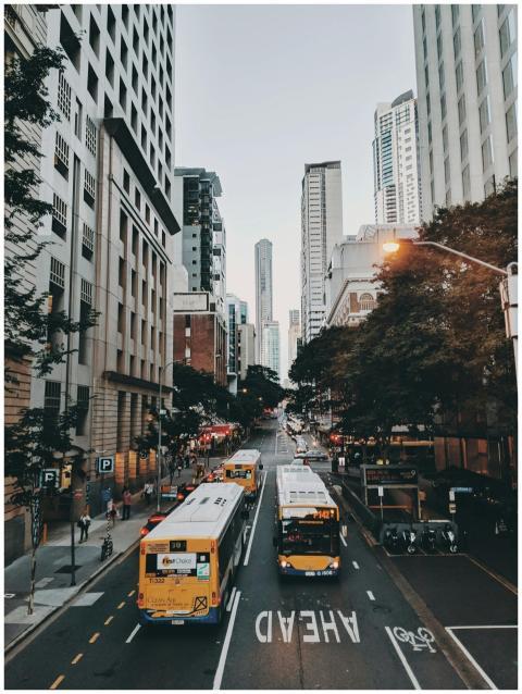 Dynamic urban scene featuring buses and pedestrian