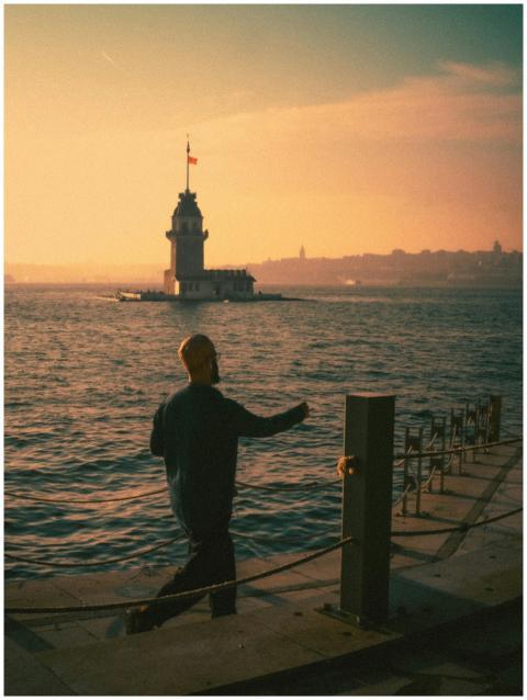A man walks along the Bosphorus with Maiden's Towe