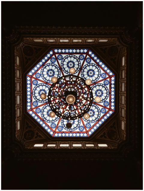 Intricate stained glass ceiling with chandelier in
