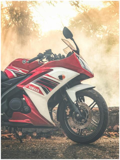 A sleek red Yamaha motorcycle parked outdoors surr