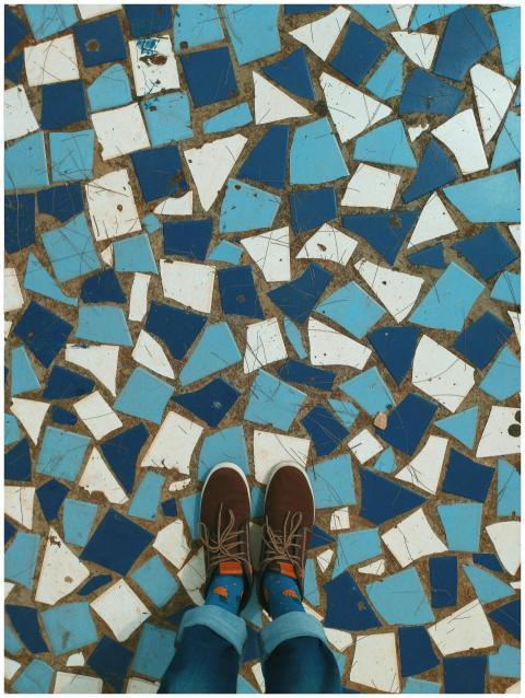 Top view of brown shoes on a vibrant blue and whit