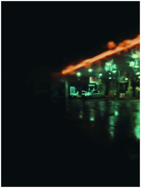 Defocused cars on gas station with neon illuminati