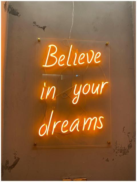 Bright neon sign on wall reading 'Believe in your