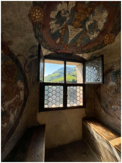 A scenic mountain view through a frescoed window i
