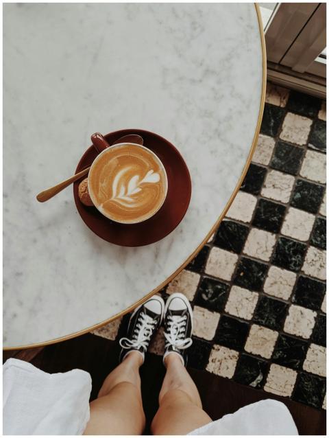 Overhead view of a latte with art on a marble tabl