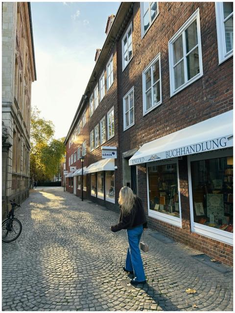 Woman walking on a quaint European street lined wi