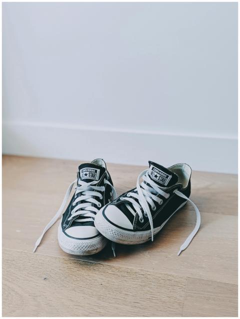 Two classic black sneakers with white shoelaces, p