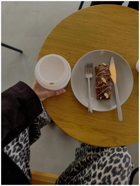 Overhead shot of a coffee cup and pastry on a circ